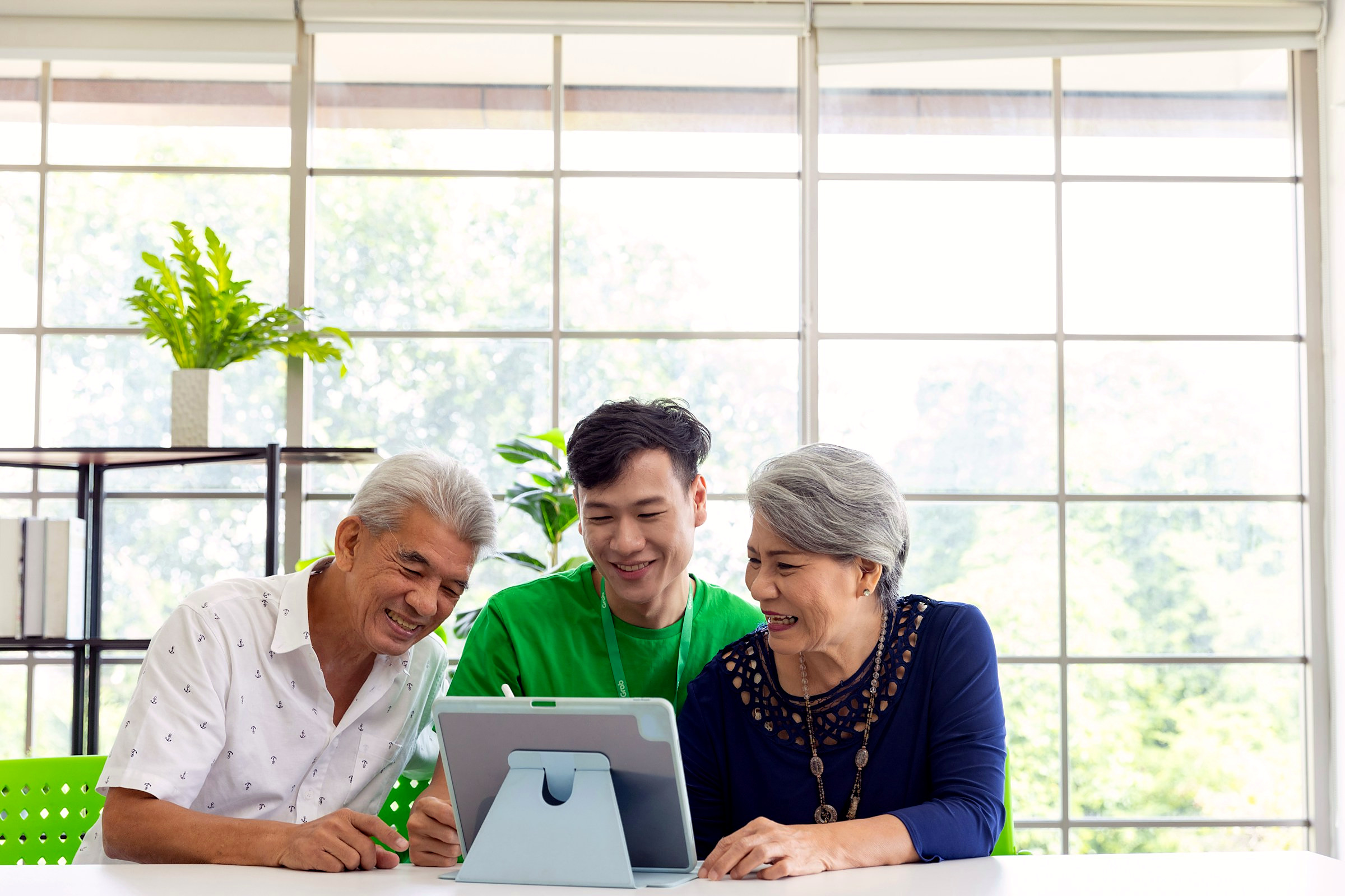 An older couple going through plan options with an agent at a bright kitchen table